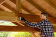 © ronstik - man restores timber frame shed color with wood protective paint