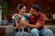 © Drazen - Happy couple and their dog relaxing on porch.