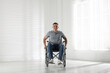 © New Africa - Young man in modern wheelchair at home