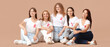 © Pixel-Shot - Beautiful women with pink ribbons sitting on beige background. Breast cancer awareness concept