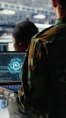 Poster - Vertical video Army programmer in high tech server hub uses AI application on laptop to review reconnaissance information. Data center IT expert wearing military uniform uses AI on notebook to plan