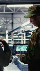 Poster - Vertical video Military commander and female programmer in data center tracking coordinates using notebook software. Soldier and african american woman in server hub analyzing reconnaissance data