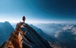 © Herlita - Person standing on a mountain peak overlooking a vast landscape.
