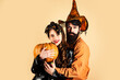 © Volodymyr - Best friends celebrated Halloween. Trick or treat. Halloween couple with pumpkin and Halloween makeup. Man and woman in witch hat celebrating Halloween.