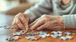 © 金 先生 - Elderly woman concentrating on solving jigsaw puzzle at wooden table, senior mental exercise and cognitive stimulation for memory care and dementia prevention.