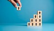 © luzaein - Business growth and success concept. Hand placing a wooden block with an arrow on a rising stack.