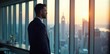 © Chanchai - Confident business leader standing in modern office, looking thoughtfully at cityscape through large window Strategic planning, success, vision, leadership, future , development, motivation