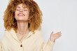 © SHOTPRIME STUDIO - Happy woman with curly hair smiling joyfully against a plain light background, exuding positivity and confidence, showcasing a relaxed and cheerful expression with arms raised