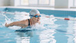 © Olia - Senior woman enjoying swimming exercise in bright indoor pool, healthy aging fitness concept