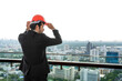 © Jack Tamrong - Good looking Caucasian businessman wearing safety helmet standing at skyscraper downtown  high rise office balcony