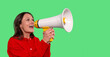 © Iryna - Woman enthusiastically using a megaphone to share a message while smiling against a vibrant green background