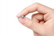 © Cheewynn - A hand delicately holding a diamond engagement ring with a white background