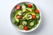 © Rubens - Fresh mixed greens salad with avocado, cherry tomatoes, cucumbers, and pumpkin seeds on white background