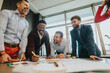 © qunica.com - A team of diverse professionals engaged in a brainstorming session, collaborating on a project in a contemporary office environment, symbolizing teamwork, creativity, and effective communication.