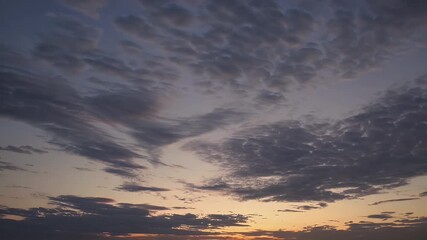Wall Mural - the sky gradually lightens just dawn mesmerizing time lapse showing cirrostratus clouds glowing soft yellows oranges while darker clouds pass creating cinematic and