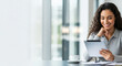 © Kamran - A smiling businesswoman uses a tablet at her office desk, representing a positive work environment and modern productivity. Perfect for business blogs