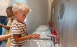 © lordn - Children from diverse backgrounds washing hands with soap at preschool sinks, practicing good hygiene habits.