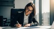 © Lestari710 - Smiling businesswoman signs documents in office