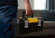 © Mahmuda - Man Carrying a Yellow and Black Plastic Toolbox Indoors