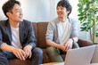 © Daisuke Morita - パソコンの前で話をしている2人の日本人男性