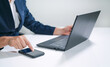 © Sakorn - Business man  using a laptop and a cell phone at the same time.