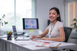 © Apichat - woman is sitting at a desk with a laptop and a notebook