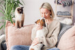 © Tatyana Gladskih - Happy woman playing with her dog on the couch at home