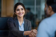 © UniqGraphicX - Business people handshake during job interview in sleek office with Indian female leader and applicant