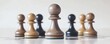 © kirania - Light-colored chess pawn surrounded by darker pieces.