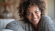 © Johannes - portrait of a beautiful mid adult woman smiling at home middle aged african woman in casual looking at camera with copy space cheerful mixed race girl relaxing at home with big laugh no logos no bran
