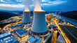 © siraphol - Large nuclear complex at night with cooling towers and industrial structures illuminated