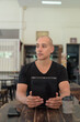 © Ranta Images - Bald Hispanic man sitting in outdoors cafe restaurant using digital tablet computer