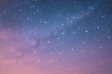 Wall Mural - A serene night sky blanketed in twinkling stars, transitioning from a deep blue at the top to a soft pink hue near the horizon