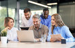 © ty - Successful businesspeople working in a coworking space working with laptop discussing strategy and business plan in modern office
