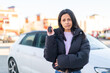 © luismolinero - Young woman at outdoors holding car keys at outdoors with sad expression