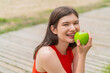 © luismolinero - Young pretty woman at outdoors eating an apple