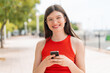 © luismolinero - Young woman with glasses at outdoors sending a message with the mobile