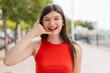 © luismolinero - Young woman with glasses at outdoors making phone gesture. Call me back sign