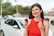 © luismolinero - Young pretty Ukrainian woman holding car keys at outdoors inviting to come with hand. Happy that you came