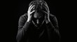 © Nurlinda - A man looks stressed, looking down and holding his head in his hands. Dramatic lighting creates deep shadows, highlighting his expression of pain and anxiety.