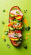 Three beautifully arranged creative toasts sit on a white rectangular plate, topped with slices of ham, tomatoes, and fresh herbs
