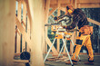 © Tomasz Zajda - Skilled Carpenter Working With a Miter Saw in a Wooden Construction Site