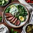 © Bayu - Top view of grilled lamb and vegetables with tzatziki in a Mediterranean keto lunch