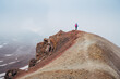 © Soloviova Liudmyla - Lonely female backpacker dressed rain cover with backpack and trekking poles making acclimatization trek around Lenin peak base camp climbing Petrovsky Peak 4910 m, Pamir mountains range, Kyrgyzstan.