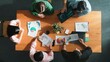 © InfiniteFlow - Top view of project manager using tablet to analyze data and financial chart while marketing team working together to brainstorm marketing campaign or planning strategy at meeting room. Convocation.