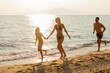 © BGStock72 - Joyful moments at sunset on the beach with family enjoying a summer day