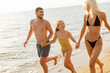 © BGStock72 - Family enjoying a summer day at the beach while playing in the surf