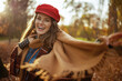 © Alliance - Hello autumn. smiling modern woman in red hat with scarf and gloves in the city park.