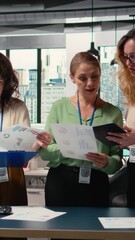 Poster - Vertical Video Group of empowered businesswomen collaborate in a modern office, reviewing data, performance indicators and project reports. Demonstrate strategic thinking and corporate feminism