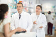 © JackF - Polite male and female pharmacists speaking to woman customer buying medical preparation in large drugstore